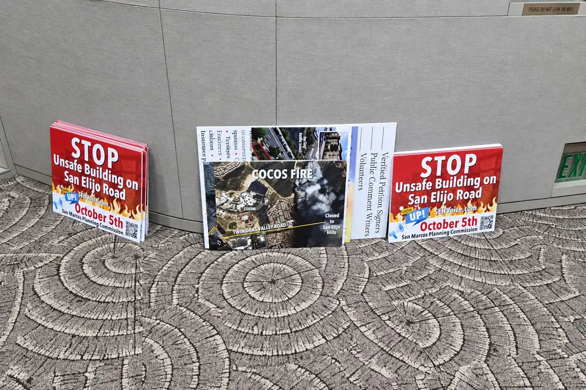 Signs opposing a proposed condominium project in San Elijo Hills are lined up ahead of Monday evening’s San Marcos Planning Commission meeting. Photo by Jim Trageser