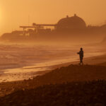 A fisherman casts a line near the shuttered San Onofre Nuclear Generating Station, where more than 1,600 tons of spent nuclear fuel remain stored. Photo by Frank Armstrong