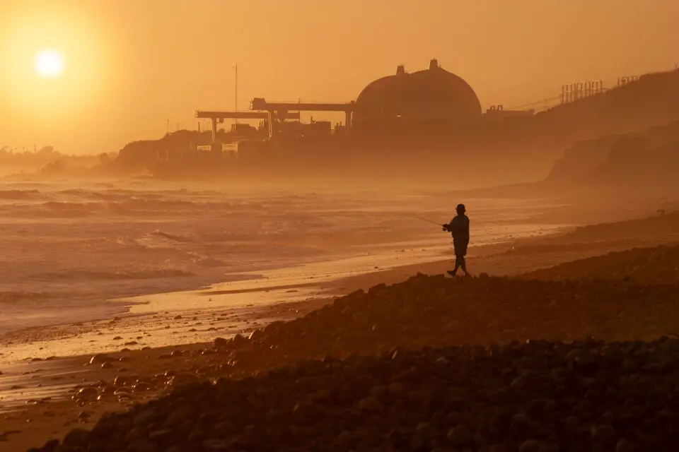 A fisherman casts a line near the shuttered San Onofre Nuclear Generating Station, where more than 1,600 tons of spent nuclear fuel remain stored. Photo by Frank Armstrong