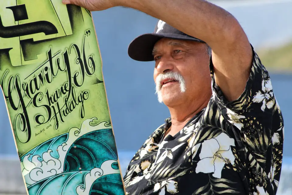Larry Hidalgo holds a Gravity skateboard made in honor of his son, Shane Hidalgo, an Oceanside professional skateboarder who died in 2012. Photo by Samantha Nelson