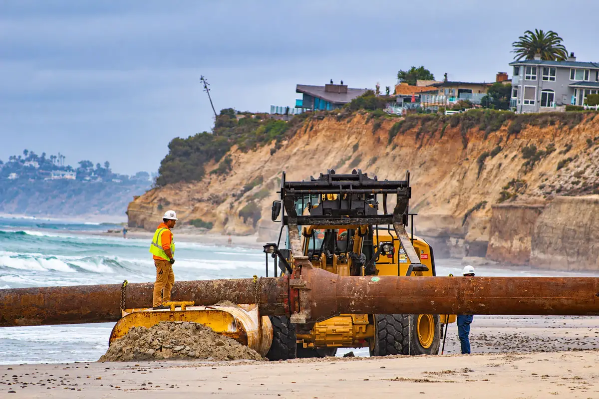 Workers assemble large dredging pipes at Fletcher Cove in 2024 for a U.S. Army Corps of Engineers project that placed approximately 700,000 cubic yards of sand along Solana Beach's coastline, widening beaches by about 150 feet. File photo/Jordan P. Ingram
