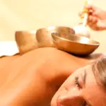 Save Download Preview Woman in wellness and spa setting having a singing bowl therapy session