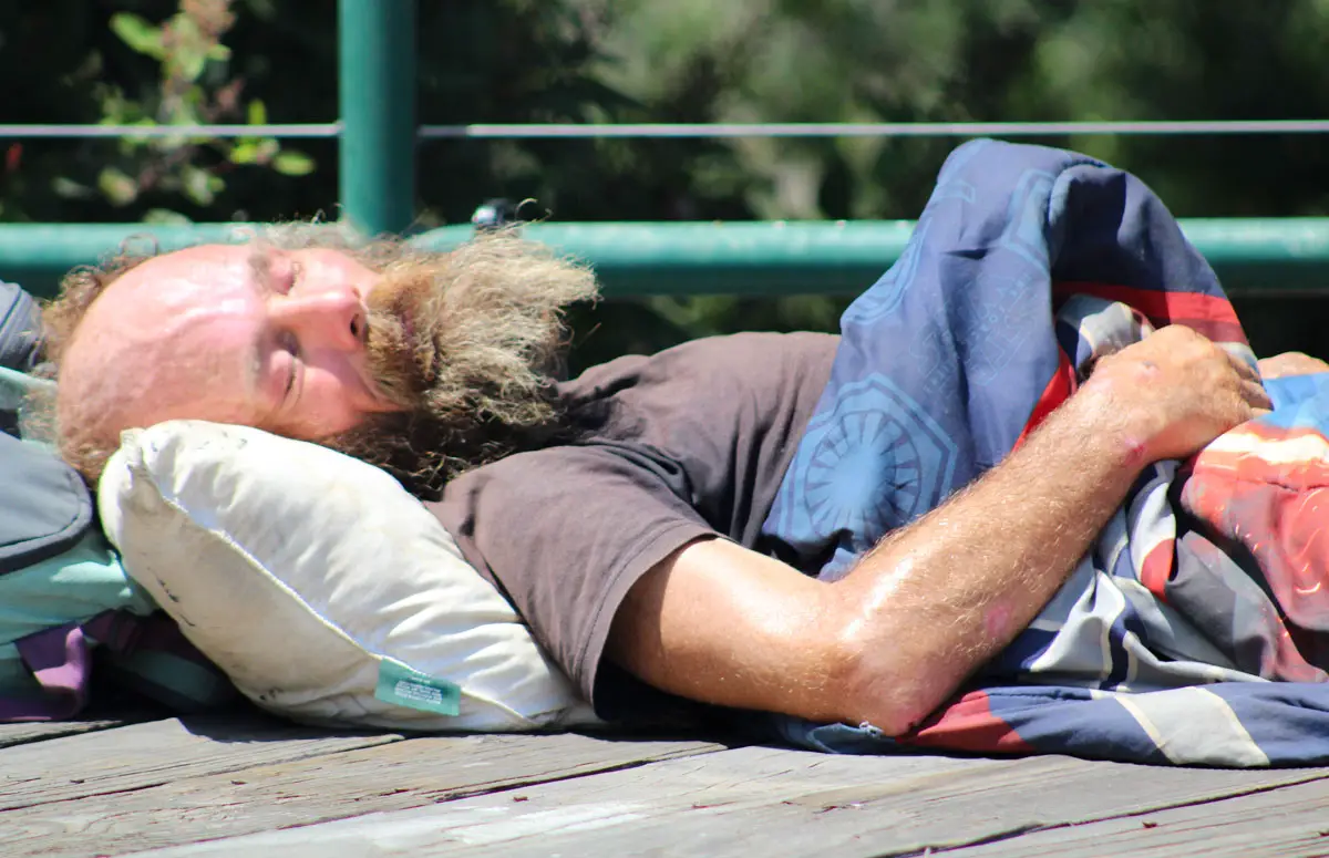 A homeless man sleeps on the overpass near Cottonwood Creek Park on Aug. 9 in Encinitas. The County of San Diego is launching homeless outreach teams to address homelessness in North County. Photo by Jordan P. Ingram